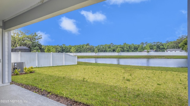 view of yard with a water view, central AC, and a fenced backyard