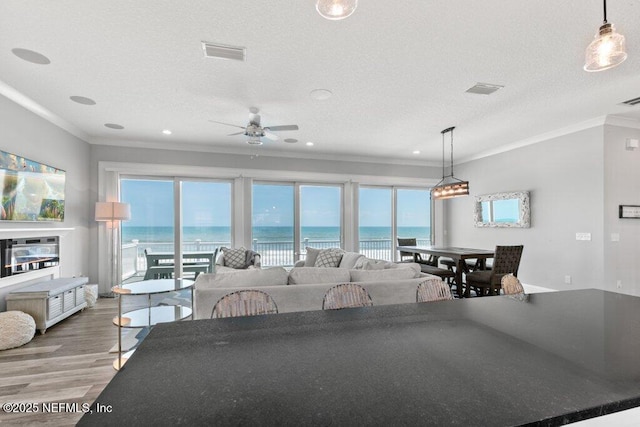 3083 S Ponte Vedra Blvd, Ponte Vedra Beach, FL 32082 - living room featuring ornamental molding, a ceiling fan, wood finished floors, a water view, and a textured ceiling