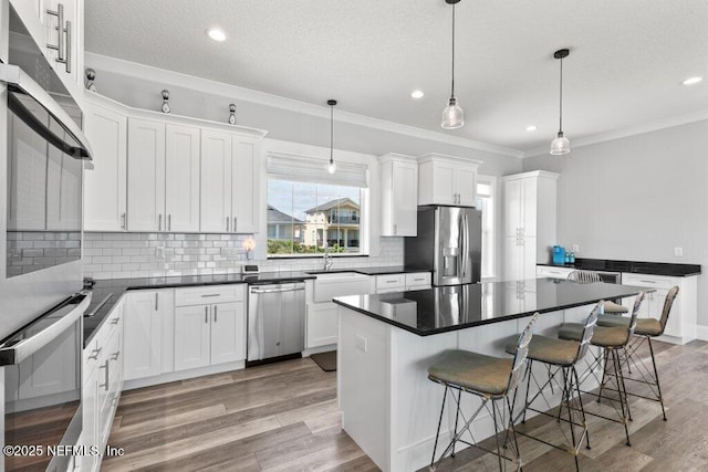 3083 S Ponte Vedra Blvd, Ponte Vedra Beach, FL 32082 - kitchen with appliances with stainless steel finishes, tasteful backsplash, dark countertops, white cabinets, and a breakfast bar