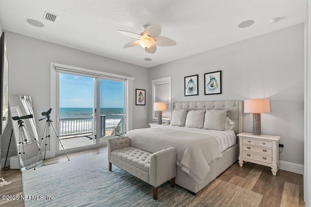 3083 S Ponte Vedra Blvd, Ponte Vedra Beach, FL 32082 - bedroom with access to outside, dark wood-style flooring, baseboards, a water view, and a textured ceiling