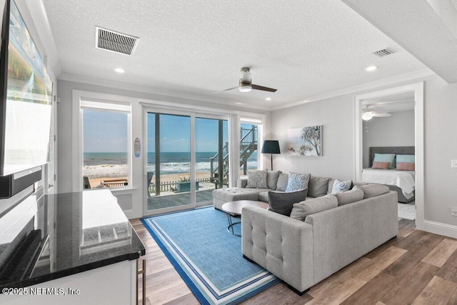 3083 S Ponte Vedra Blvd, Ponte Vedra Beach, FL 32082 - living area featuring ceiling fan, a textured ceiling, ornamental molding, wood finished floors, and a water view