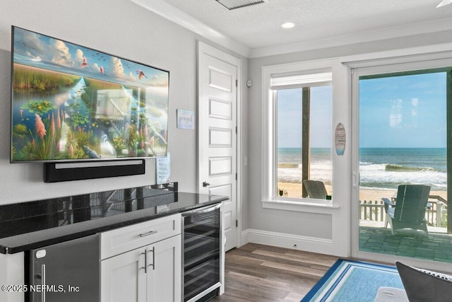 3083 S Ponte Vedra Blvd, Ponte Vedra Beach, FL 32082 - bar featuring beverage cooler, dark wood finished floors, baseboards, a water view, and a textured ceiling