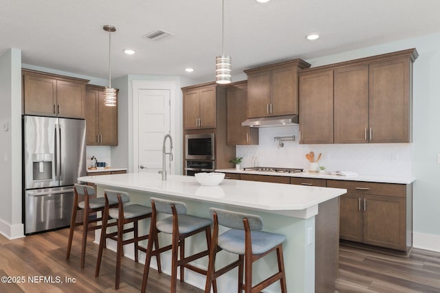 55 Rainbow Trout Ln, Ponte Vedra, FL 32081 - kitchen with appliances with stainless steel finishes, under cabinet range hood, dark wood-style flooring, light countertops, and backsplash