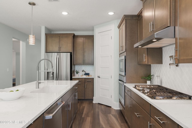 55 Rainbow Trout Ln, Ponte Vedra, FL 32081 - kitchen with stainless steel appliances, a sink, under cabinet range hood, dark wood-style floors, and tasteful backsplash