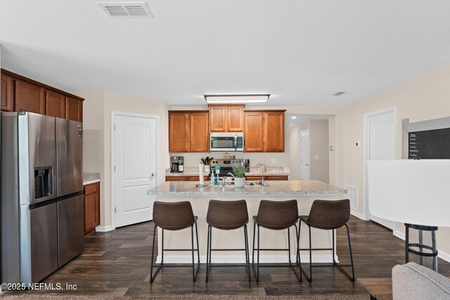 kitchen featuring light countertops, appliances with stainless steel finishes, dark wood finished floors, and visible vents