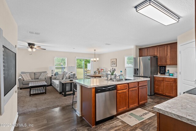 kitchen with dark wood-style flooring, stainless steel appliances, a sink, and light countertops