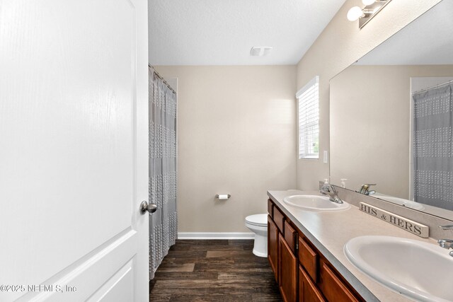 full bathroom with baseboards, a sink, and wood finished floors