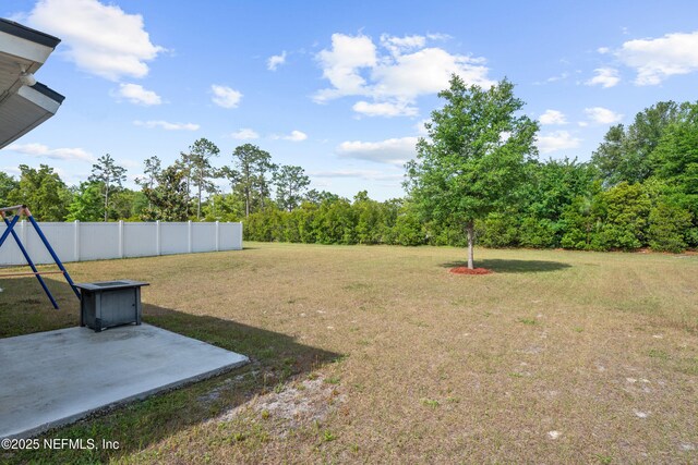 view of yard featuring fence and a patio