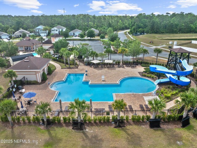 community pool with fence and a water slide