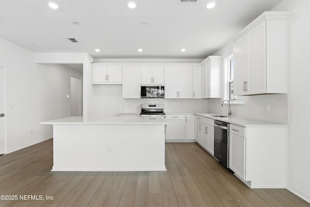 2442 Glade Ln, Green Cove Springs, FL 32043 - kitchen with stainless steel appliances, a sink, a center island, tasteful backsplash, and white cabinets