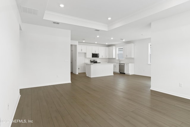 2442 Glade Ln, Green Cove Springs, FL 32043 - unfurnished living room with a tray ceiling, recessed lighting, baseboards, dark wood-style flooring, and ornamental molding
