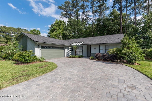 7372 Secret Woods Dr, Jacksonville, FL 32216 - ranch-style house featuring decorative driveway, a garage, and a front yard