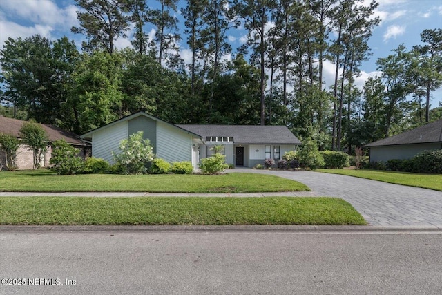 7372 Secret Woods Dr, Jacksonville, FL 32216 - mid-century inspired home featuring decorative driveway and a front yard