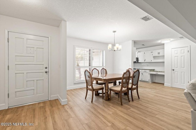 7372 Secret Woods Dr, Jacksonville, FL 32216 - dining space with a chandelier, light wood finished floors, baseboards, and a textured ceiling