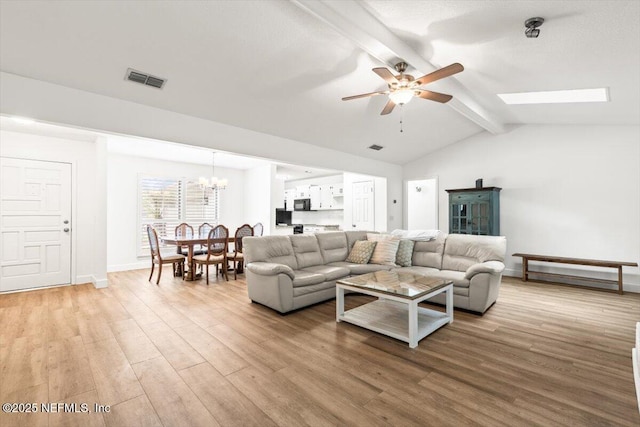 7372 Secret Woods Dr, Jacksonville, FL 32216 - living area with a ceiling fan, a chandelier, light wood finished floors, and baseboards