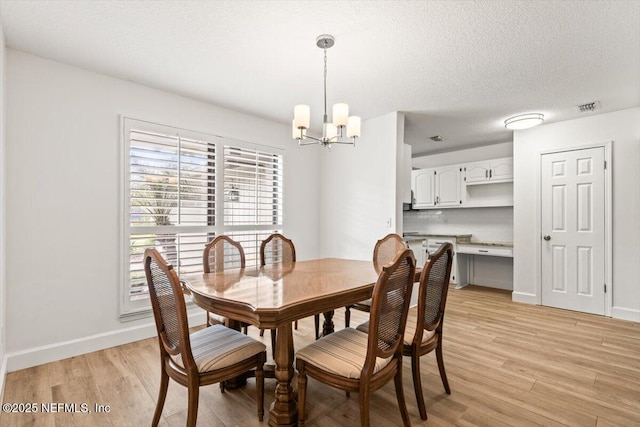 7372 Secret Woods Dr, Jacksonville, FL 32216 - dining space featuring a chandelier, light wood-style flooring, baseboards, and a textured ceiling