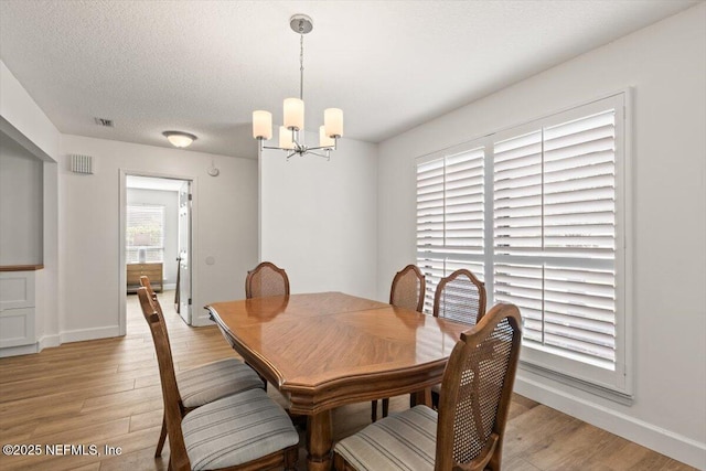 7372 Secret Woods Dr, Jacksonville, FL 32216 - dining space with a chandelier, light wood-style floors, and baseboards