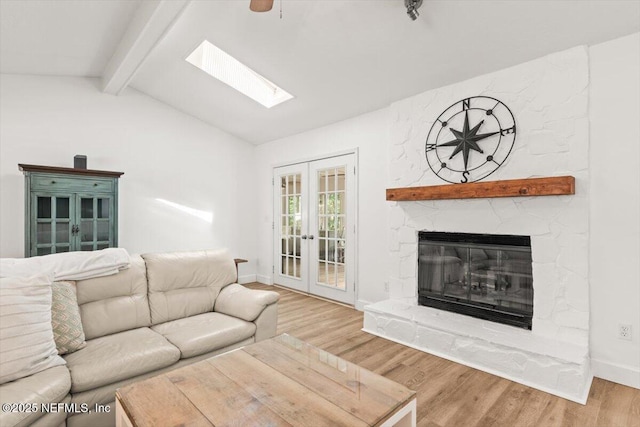 7372 Secret Woods Dr, Jacksonville, FL 32216 - living area with wood finished floors, baseboards, a skylight, a stone fireplace, and french doors