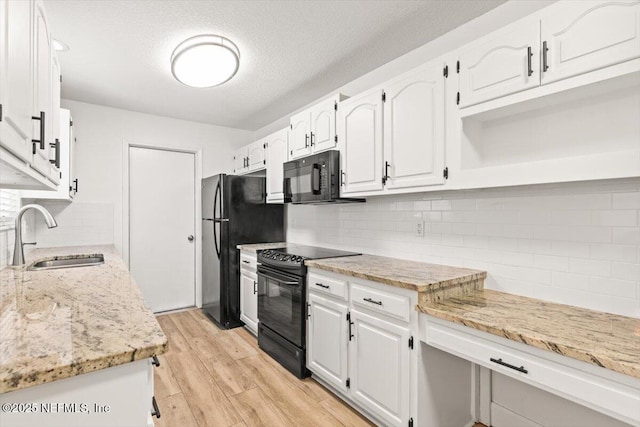 7372 Secret Woods Dr, Jacksonville, FL 32216 - kitchen featuring a sink, black appliances, backsplash, white cabinetry, and light wood-type flooring