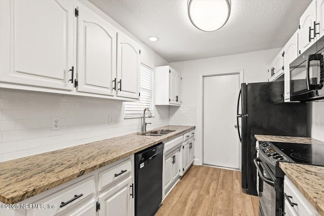 7372 Secret Woods Dr, Jacksonville, FL 32216 - kitchen with black appliances, a sink, white cabinetry, light wood-type flooring, and light stone countertops