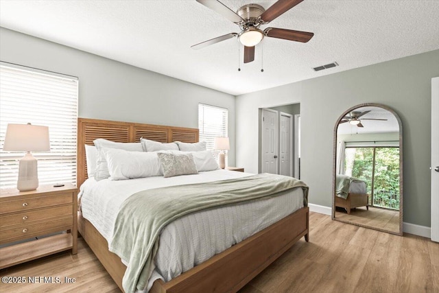 7372 Secret Woods Dr, Jacksonville, FL 32216 - bedroom with light wood-type flooring, a ceiling fan, baseboards, a textured ceiling, and a closet