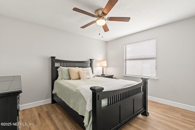 7372 Secret Woods Dr, Jacksonville, FL 32216 - bedroom featuring baseboards, light wood-style floors, a ceiling fan, and a textured ceiling