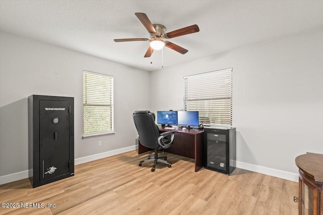 7372 Secret Woods Dr, Jacksonville, FL 32216 - office area featuring light wood-style flooring, ceiling fan, baseboards, and wine cooler