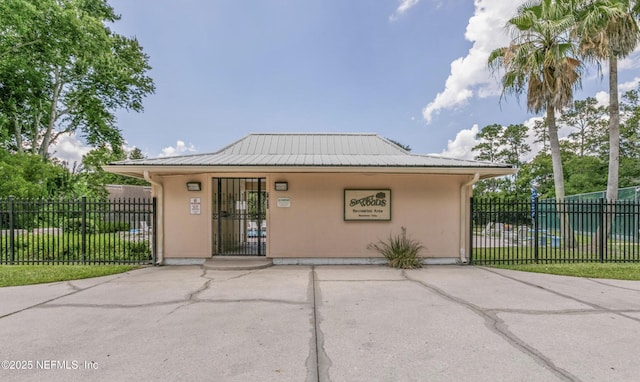 7372 Secret Woods Dr, Jacksonville, FL 32216 - view of front facade featuring a fenced front yard, stucco siding, and metal roof
