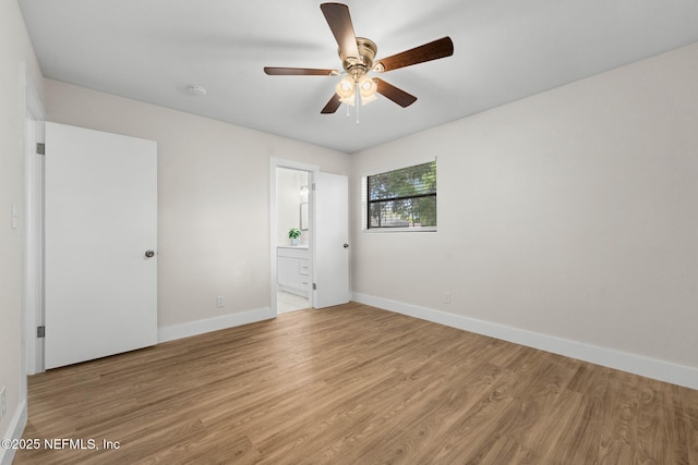unfurnished bedroom with baseboards, ensuite bath, ceiling fan, and light wood-style floors