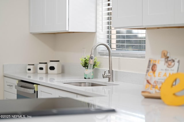 kitchen featuring light countertops, white cabinetry, a sink, and dishwasher