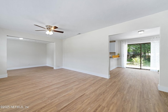 spare room with a ceiling fan, baseboards, visible vents, and light wood-style floors