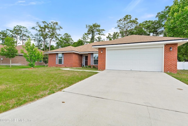 ranch-style home featuring brick siding, driveway, fence, and a front yard