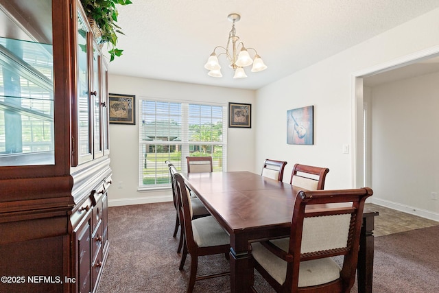 dining area featuring baseboards, dark carpet, and a notable chandelier