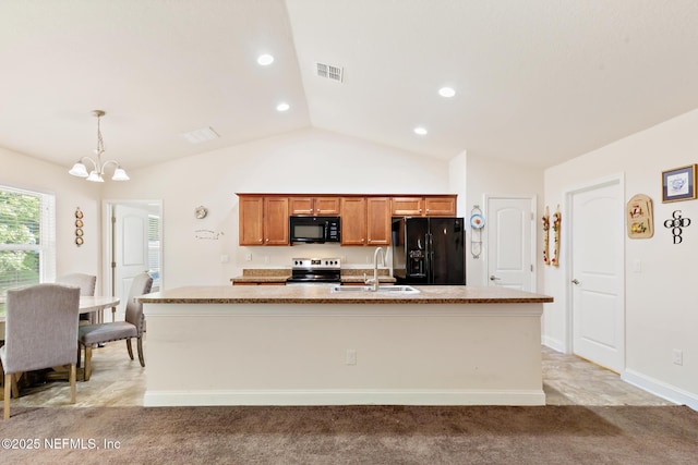 kitchen featuring a sink, a chandelier, brown cabinetry, an island with sink, and black appliances