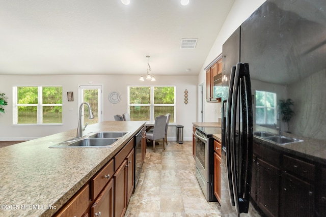 kitchen featuring brown cabinetry, a sink, baseboards, black appliances, and a notable chandelier