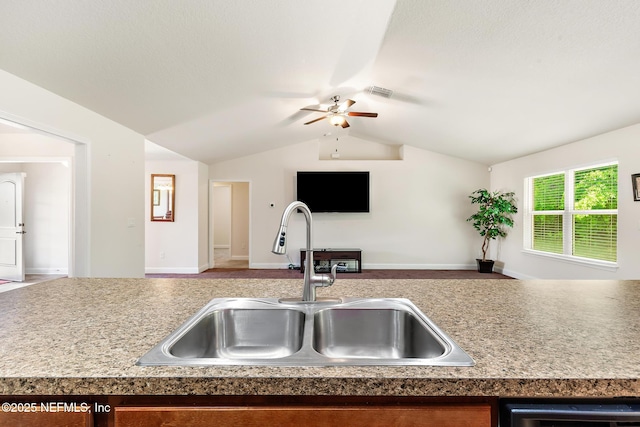 kitchen featuring a sink, visible vents, a ceiling fan, open floor plan, and vaulted ceiling