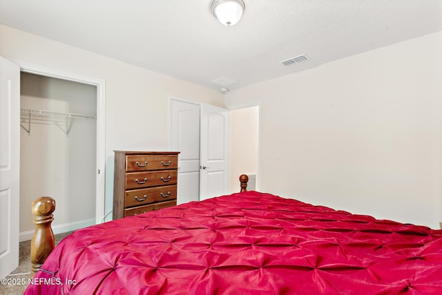 carpeted bedroom featuring visible vents, baseboards, and a closet