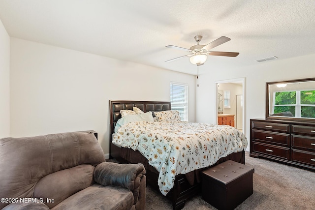 bedroom featuring multiple windows, ensuite bathroom, carpet flooring, and visible vents