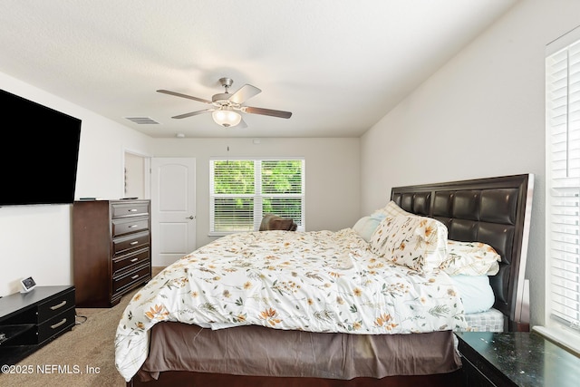 bedroom featuring light colored carpet, a ceiling fan, and visible vents