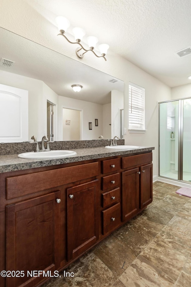 full bathroom featuring visible vents, a sink, and a stall shower