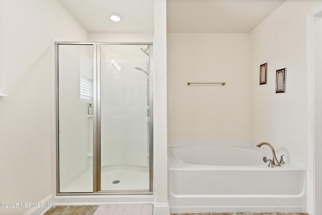 bathroom featuring a shower stall and a garden tub