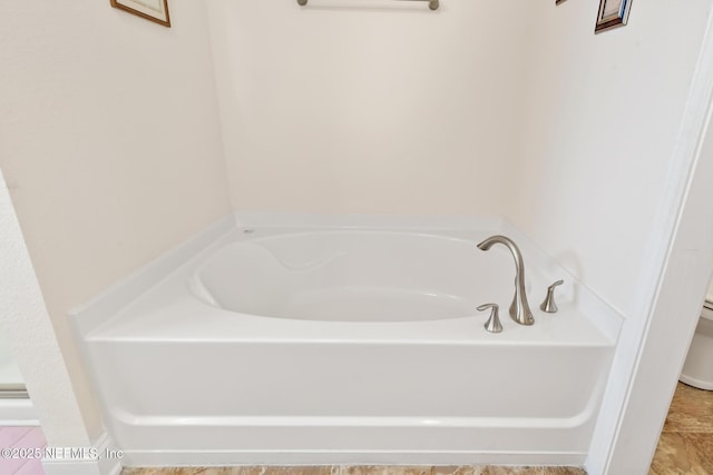 bathroom with a garden tub and toilet