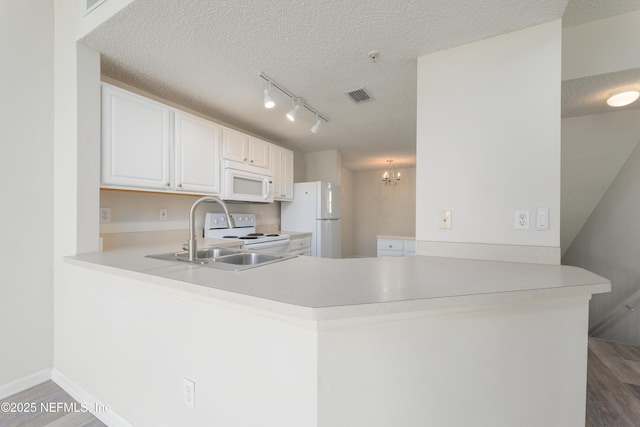 2005 Mariposa Vista Ln Unit 3-123, Saint Augustine, FL 32084 - kitchen with a sink, white appliances, a peninsula, wood finished floors, and visible vents