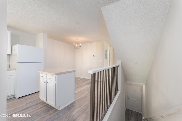 2005 Mariposa Vista Ln Unit 3-123, Saint Augustine, FL 32084 - stairway with wood finished floors, a textured ceiling, and a chandelier