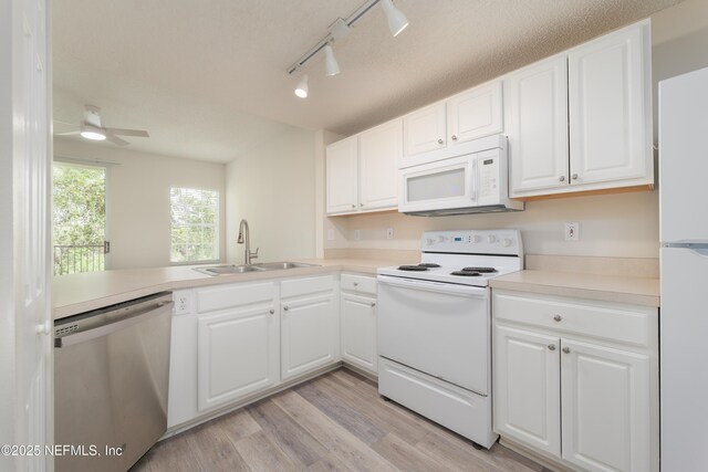 2005 Mariposa Vista Ln Unit 3-123, Saint Augustine, FL 32084 - kitchen with white appliances, light wood-style floors, white cabinets, rail lighting, and a sink