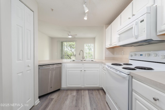 2005 Mariposa Vista Ln Unit 3-123, Saint Augustine, FL 32084 - kitchen with track lighting, white appliances, light wood-type flooring, light countertops, and a sink