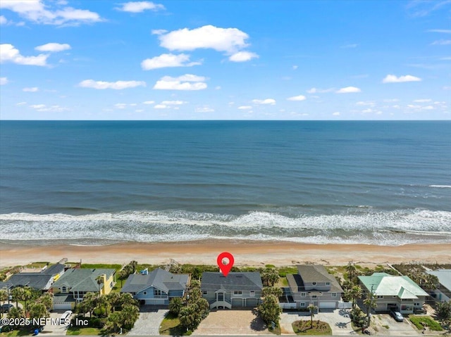 drone / aerial view with a water view, a view of the beach, and a residential view
