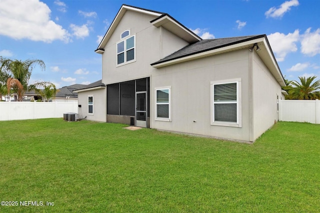 back of property with a fenced backyard, a yard, a sunroom, and cooling unit