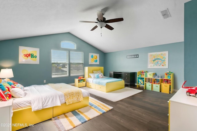 bedroom with a ceiling fan, vaulted ceiling, wood finished floors, and visible vents