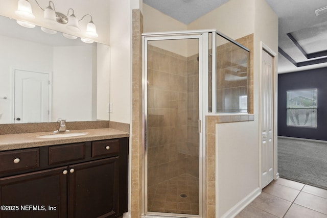 bathroom featuring vanity, baseboards, tile patterned flooring, and a stall shower